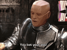 a robot says " you bet your ass " in front of a screen