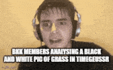 a man wearing headphones is looking at a black and white picture of grass in time .