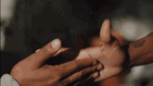 a person is holding another person 's hand with their fingers .
