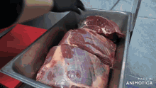 a large amount of meat is in a metal container that says made in animotica