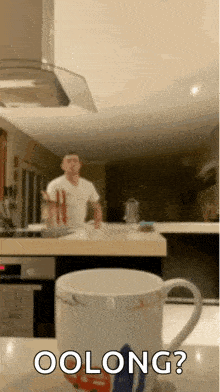 a man is standing behind a cup that says oolong on it