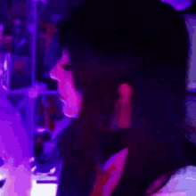 a close up of a person 's face in a purple light