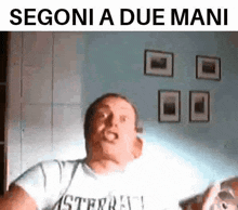 a man in a white shirt is making a funny face with the words segoni a due mani below him