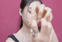 a woman wearing a headset is holding something in her hand in front of her face
