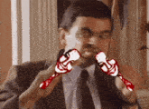 a man in a suit and tie is holding a pair of red sticks