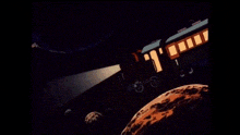 a cartoon of a train traveling through space with a light coming out of the window .