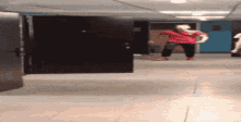a person in a red shirt stands in a hallway