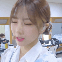 a woman with her eyes closed wearing a white shirt with a blue apron