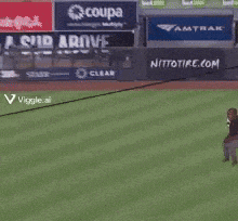 a man stands on a baseball field with a sign that says coupa on it