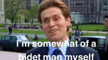 a man in a suit and tie is smiling and says " i 'm somewhat of a bidet man myself "