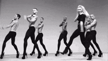 a group of men and a woman are dancing together in high heels