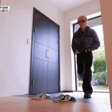 a man standing in front of a door with a sign that says ' t quiz '