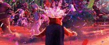 a cat is standing in front of a crowd of people with confetti flying around him .