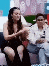 a woman in a black dress is sitting next to another woman