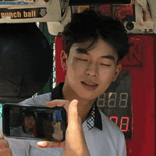 a man is taking a picture of himself with a punch ball in the background