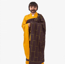 a young boy with a beard is wearing a yellow and brown robe