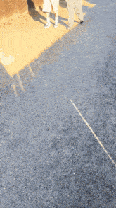 two people walking on a road with a yellow line