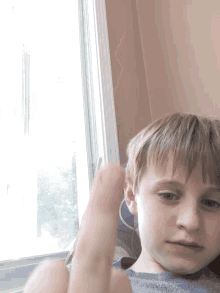 a young boy laying in front of a window