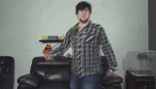 a man in a plaid shirt stands in front of a couch