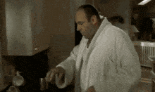 a man in a white robe is standing in a kitchen