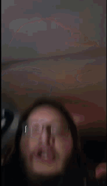 a close up of a person wearing glasses making a funny face