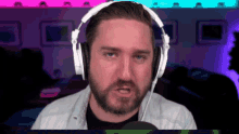 a man with a beard wears white headphones