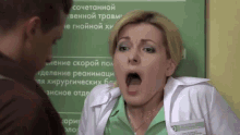 a woman in a lab coat is talking to a man in front of a sign in russian