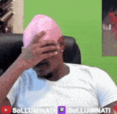a man wearing a white shirt and a pink hat covering his face