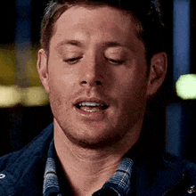 a man is making a funny face with his eyes closed .