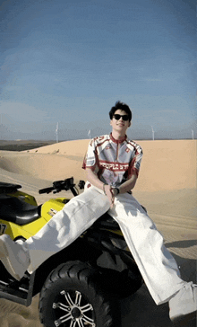 a man wearing a shirt that says " people st " sits on a yellow atv
