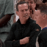 a man wearing a black jacket with the word cavs on the front