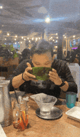 a man wearing a black shirt that says ' abercrombie & fitch ' on it is eating from a bowl