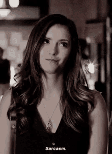 a woman wearing a necklace says sarcasm in a black shirt
