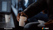 a close up of a person holding a cup of coffee with #chicagopd written on it