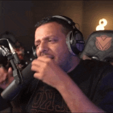 a man wearing headphones and a shirt that says oklahoma is talking into a microphone