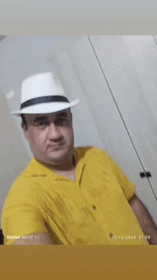 a man wearing a yellow shirt and a white hat has a sticker that says " ze bonitin "