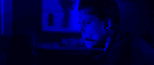 a woman in a dark room with a blue light on her face