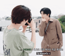a man taking a picture of another man with the word hong written on the bottom