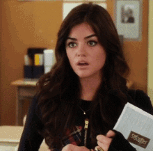 a woman is holding a notebook that says snuggle on it