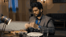 a man sitting at a table with a plate of food and a glass of water