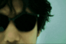 a close up of a person wearing sunglasses with a white background