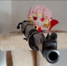 a stuffed doll with red eyes is pointing a gun at someone .