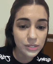 a close up of a woman 's face while wearing a black shirt .