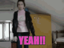 a woman in a pink shirt is holding a pink sign that says yeah