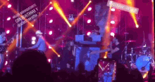 a group of people playing instruments on a stage with a sign that says #atravatratour