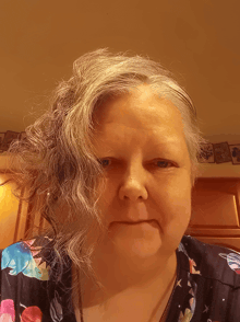 a woman with gray hair and a floral shirt