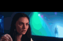 a close up of a woman 's face in front of a green light