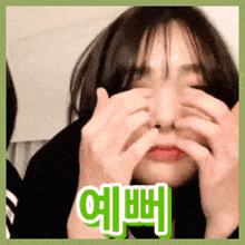 a woman is covering her eyes with her hands and a green sticker that says ' hello ' on it