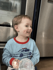 a young boy wearing a shirt with a police car on it