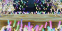 a group of people are dancing on a stage with glow in the dark sticks in the foreground .